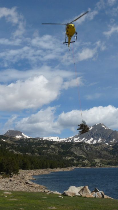 Hélicoptère en approche au-dessus du lac des Bouillouses, technicien au sol