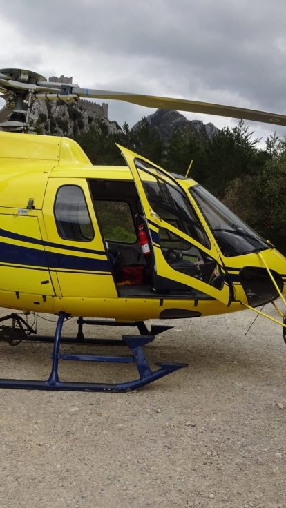 Hélicoptère AS350 Écureuil posé au sol, pick-up garé à proximité