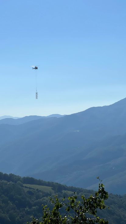 Hélicoptère posé près d'éléments en treillis destinés à un pylône électrique