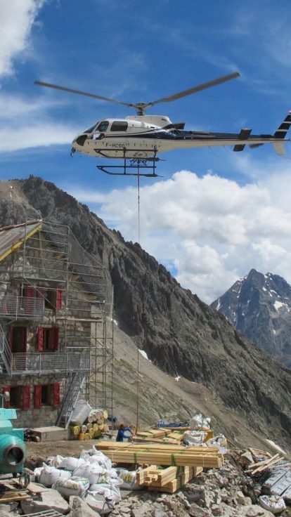 Hélicoptère livrant des matériaux à un refuge de montagne en travaux