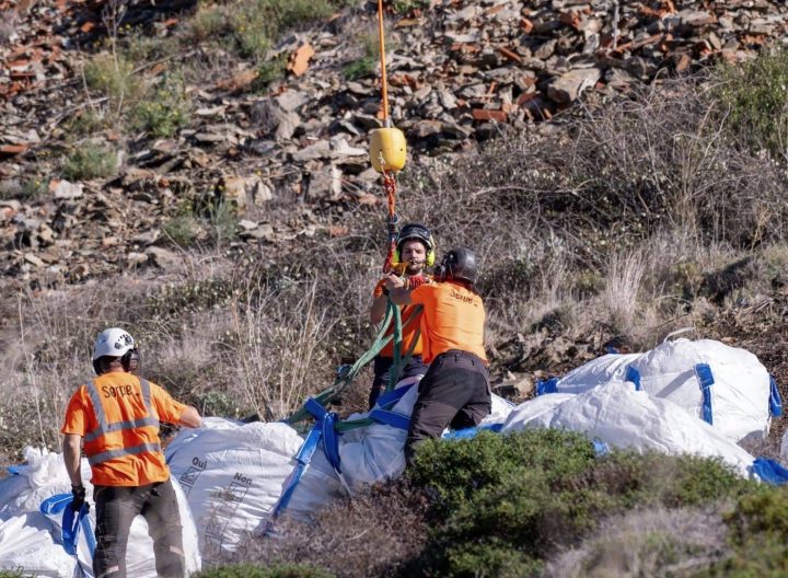 Equipo en tierra enganchando big bags bajo la eslinga