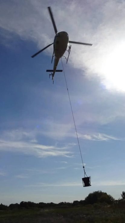 Helicóptero y cubeta de descarga en vuelo